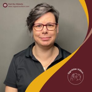 Image of Leah smiling at the camera wearing glasses and black polo shirt